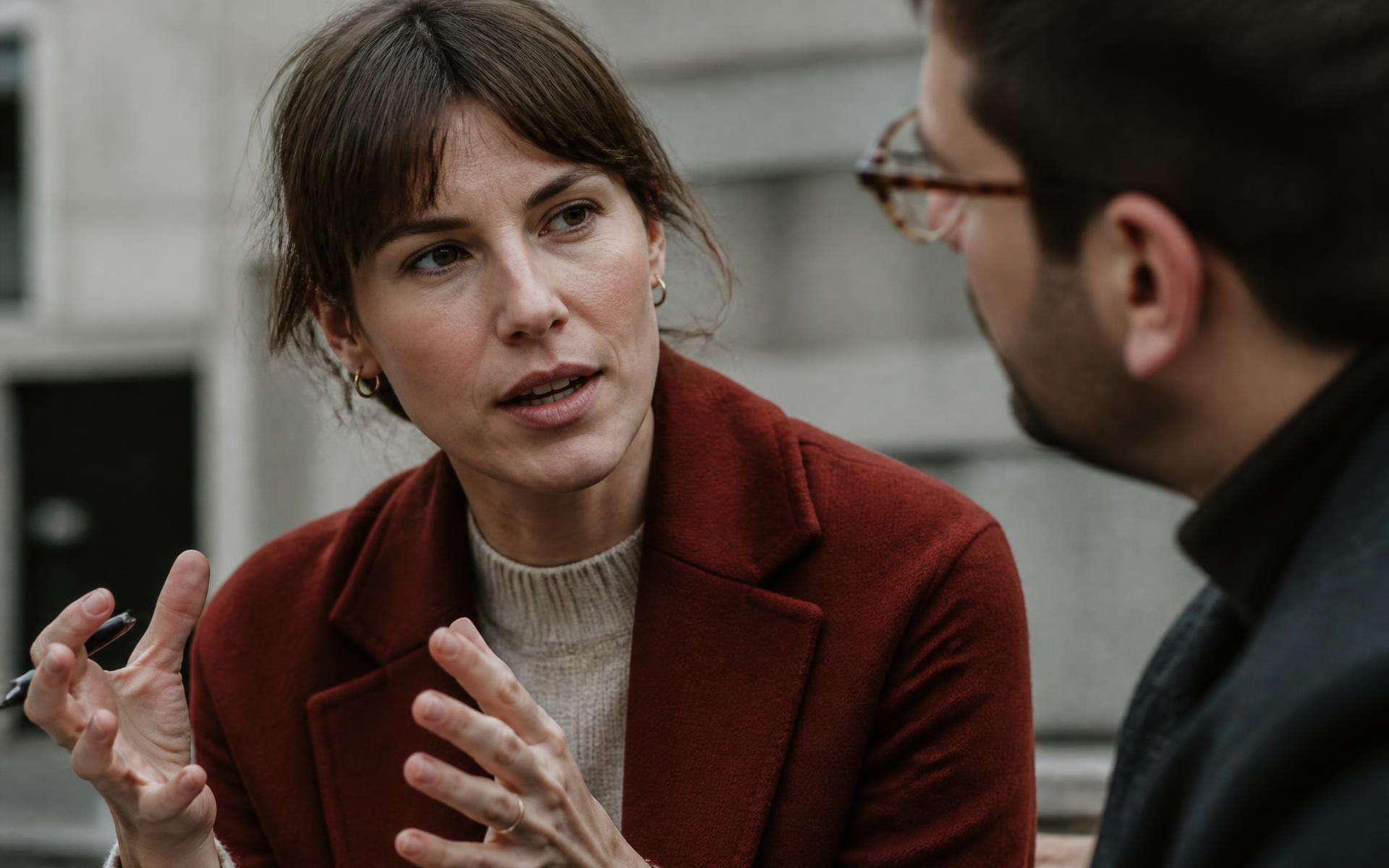 Very close view of a representative mid-conversation with a customer on a city street, both engaged and making eye contact